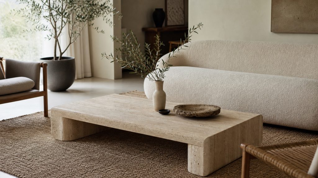 Table basse en pierre travertin dans un salon contemporain lumineux aux tons naturels